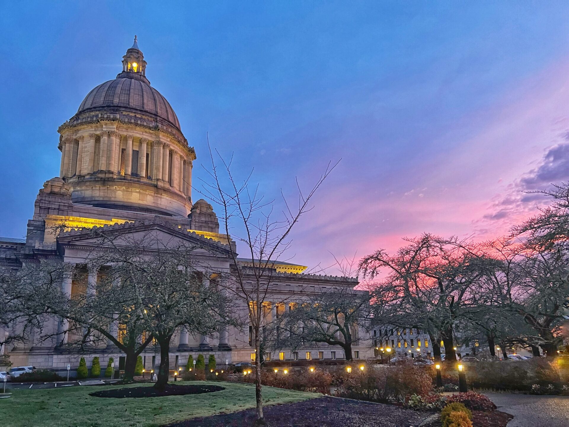 Washington State Capitol building at dusk with illuminated dome and colorful evening sky in Olympia